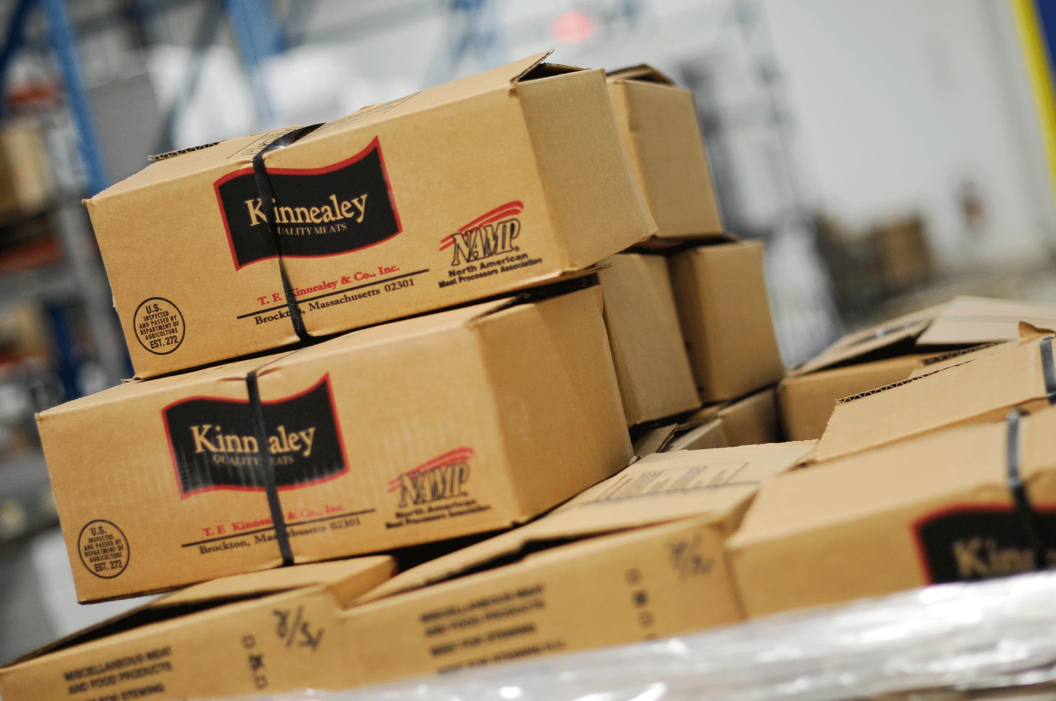 Several Kinnealey boxes stacked on top of each other in a warehouse.
